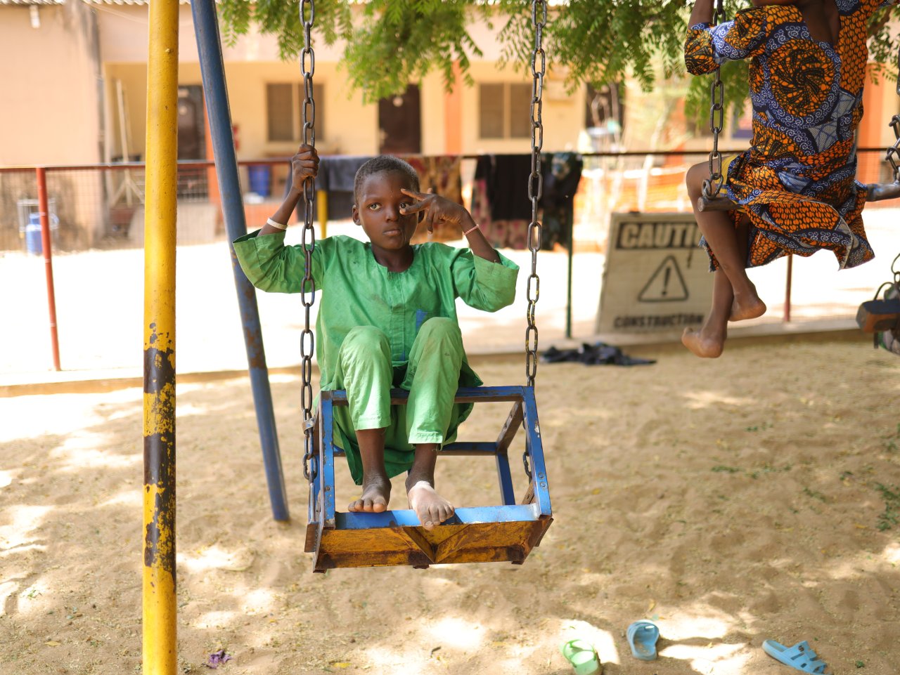 Biliya Muhammadu Nura, 11 ans, pose pour une photo sur une balançoire dans la cour de récréation de l'hôpital pour enfants Noma, soutenu par MSF, dans l'État de Sokoto, au Nigéria.