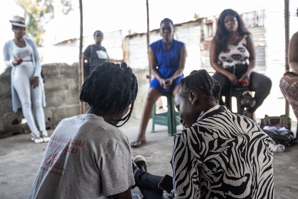 Un membre de l'équipe de proximité de MSF, à gauche, s'entretient avec un patient de la clinique mobile de MSF dans un quartier défavorisé de Beira, au Mozambique.