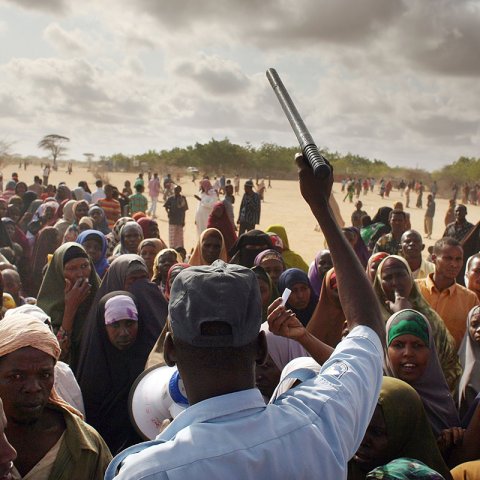 Entre 2006 et 2011, les violences s’intensifient en Somalie et la population, en quête de sécurité, continue de fuir vers le Kenya. En septembre 2009, les camps atteignent le triple de leur capacité. Les abris, l’eau potable et les installations sanitaires manquent Ici, un agent de sécurité essaie de contrôler un groupe de réfugiés qui tentent désespérément de se rendre dans un camp moins surpeuplé.