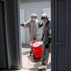 Deux personnes en combinaison effectuent la prévention des infections dans le centre MSF à Mossoul en Irak.