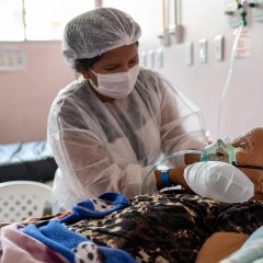 Personne âgée se faisant soigner sur un lit d’hôpital.