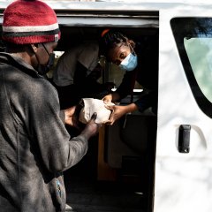Selma, une travailleuse de terrain MSF, remet à un bénéficiaire un kit d'injection préemballé depuis un véhicule MSF. Ces kits font partie du programme de réduction des risques de MSF à Maputo et réduisent le risque que courent les toxicomanes en réutilisant des aiguilles contaminées.