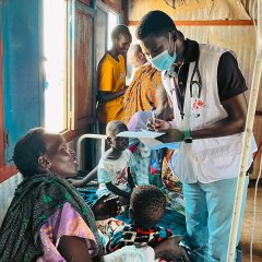 Ein Arzt untersucht ein Kind in der Masern-Station im Um Sangour Vertriebenencamp. Weisser Nil, Sudan, Juli 2023.