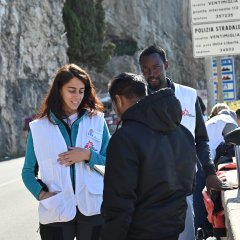 Mitarbeiter:innen informieren Menschen auf der Flucht über medizinische Unterstützung. Ventimiglia, Italien, Juli 2023.