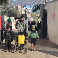 n père et ses deux enfants, tous trois déplacés à Rafah, rapportant de l’eau. Février 2024. ©MSF