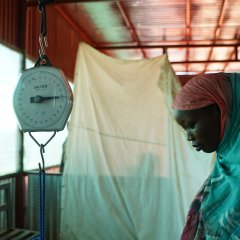 Frau wird gewogen bei einer Untersuchung im Ärzte Ohne Grenzen Spital im ZamZam Camp, 15 km südöstlich der Stadt El Fasher, Sudan. Hier leben mehr als 300 000 geflüchtete Menschen. Nord-Darfur, Februar 2024. 