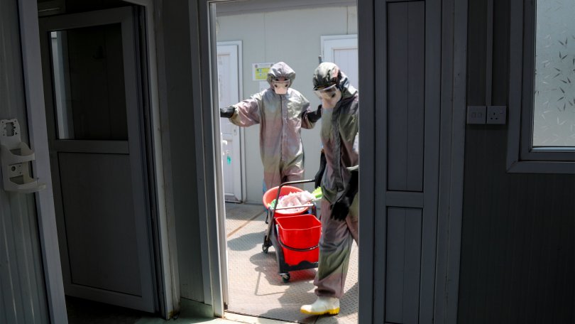 Deux personnes en combinaison effectuent la prévention des infections dans le centre MSF à Mossoul en Irak.