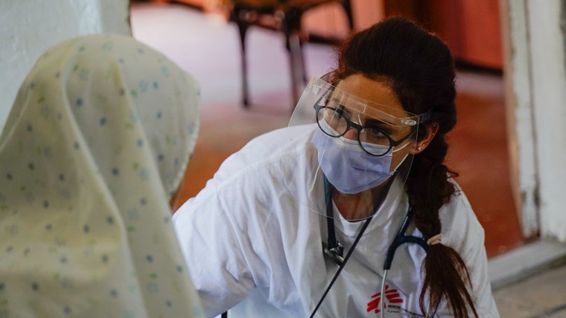Une médecin avec sa visière protectrice inspecte une patiente à Beyrouth