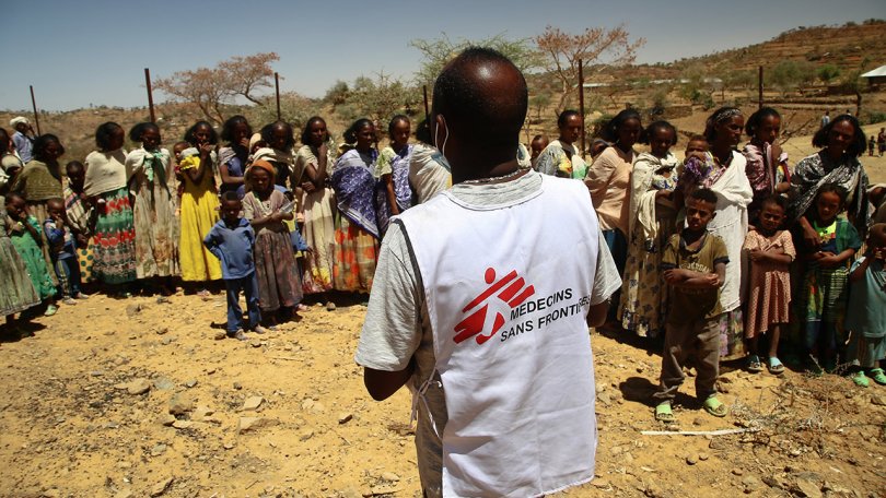 Ein MSF-Übersetzer redet mit einer Gruppe Frauen und Kinder