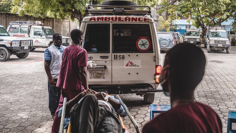 Un patient victime d'un traumatisme crânien est allongé sur un brancard, il est emmené au centre d'urgence MSF de Turgeau en ambulance.