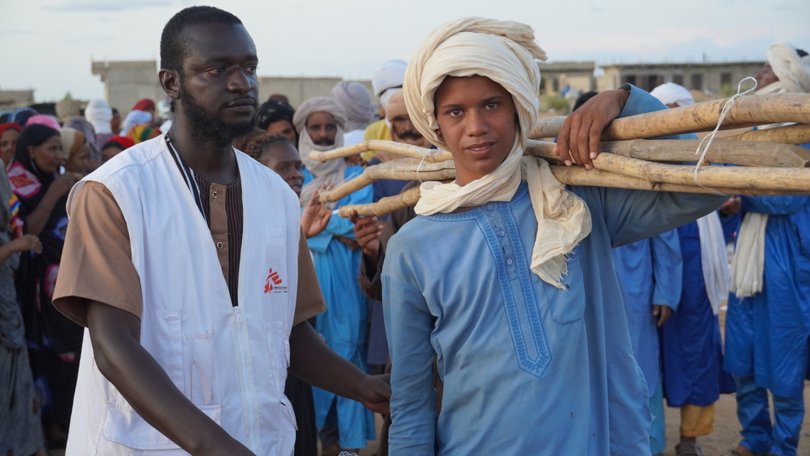 Ein junger Mann, der sein Kit erhalten hat, wird sein Zelt auf dem Gelände von Soso Koira in Gao aufbauen. Mali, September 2022. 