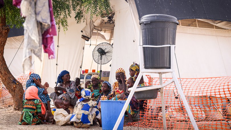 Eine Gruppe von Frauen teilt sich den Platz vor dem therapeutischen Ernährungszentrum, in dem ihre Kinder behandelt werden. Katsina, Nigeria, 24. Mai 2023.