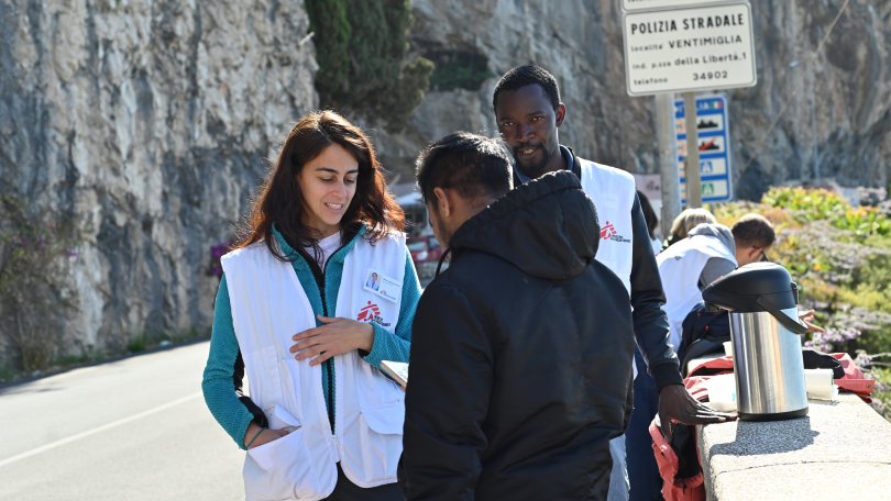 Mitarbeiter:innen informieren Menschen auf der Flucht über medizinische Unterstützung. Ventimiglia, Italien, Juli 2023.