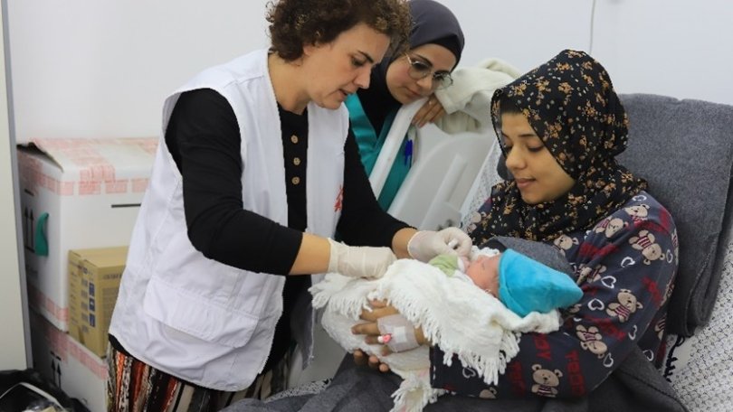 Le personnel médical de MSF discute avec un patient et examine un nouveau-né à l'hôpital Emirati de Rafah, dans le sud de Gaza.