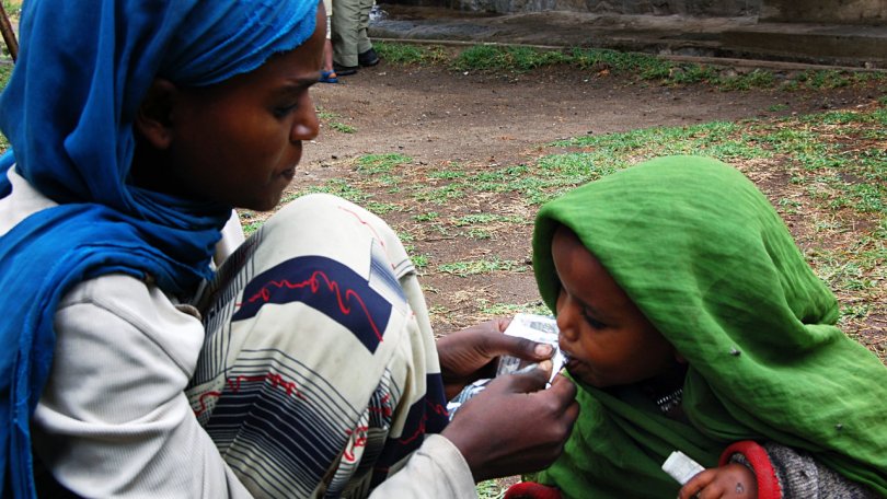 Une jeune fille nourrit sa petite soeur avec de l'alimentation thérapeutique Plumpy'nut à Shalla (Aje), Oromiya la région, Ethiopie du sud. 