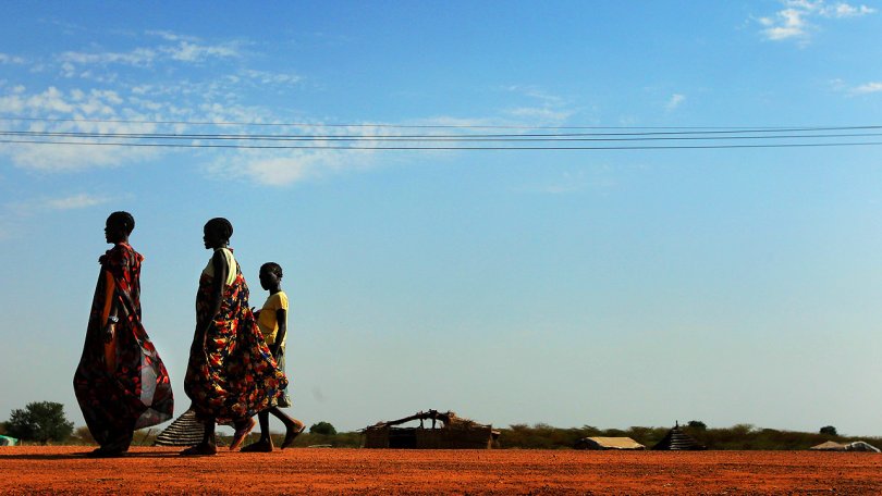 Trois femmes marchant le long d’une route dans la ville d’Abyei. La ville a été détruite durant les affrontements de 2008.