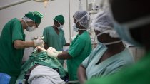 Un chirurgien de l'hôpital MSF SICA à Bangui tente d'extraire une balle profondément logée dans l'épaule d'un patient. Avril 2018