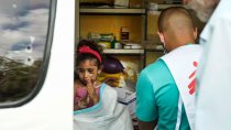 Une enfant de 3ans se fait soigner par un infirmier MSF dans une clinique mobile.
