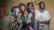 Un groupe de quatre jeunes hommes.