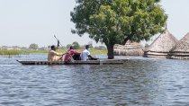 Des hommes en canoë naviguent sur les eaux de crue à Bentiu, dans l'État d'Unity, où les maisons et les moyens de subsistance (cultures et bétail) des habitants, ainsi que les centres de santé, les écoles et les marchés, sont complètement submergés par les eaux.