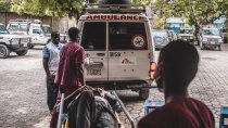 Un patient victime d'un traumatisme crânien est allongé sur un brancard, il est emmené au centre d'urgence MSF de Turgeau en ambulance.