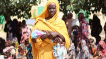  Food distribution in Nyala, South Darfur. Ikhlas Musa Ramadan, one of the many mothers admitted to MSF's program to care for lactating and pregnant women suffering from severe malnutrition, stands in line waiting for her turn to receive the food basket.